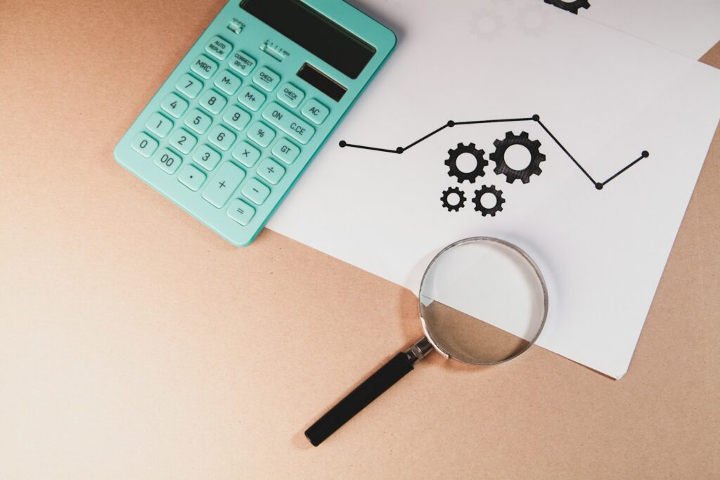 Magnifying glass over financial documents and cash, representing a bankruptcy trustee reviewing a debtor's finances