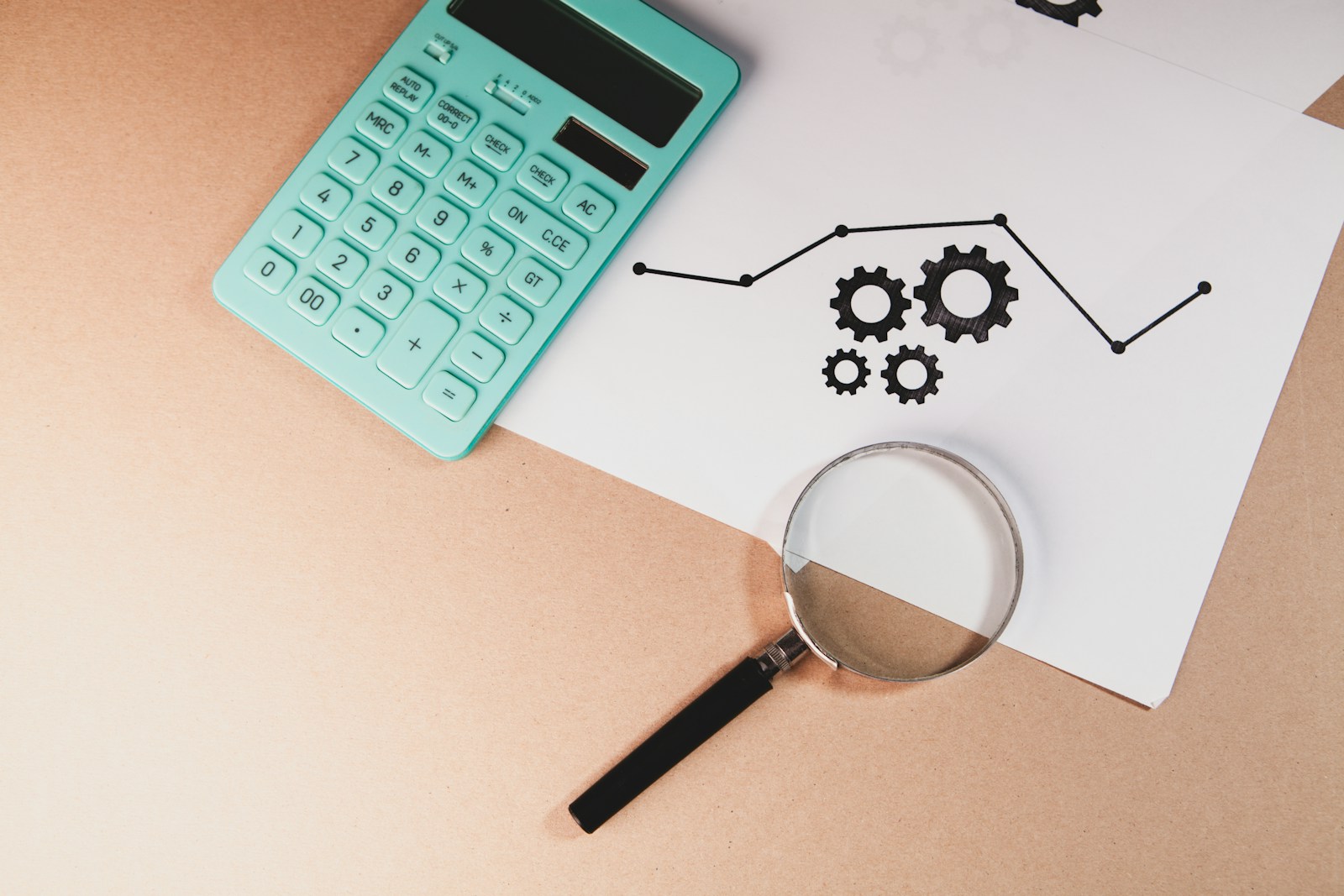 Magnifying glass over financial documents and cash, representing a bankruptcy trustee reviewing a debtor&rsquo;s finances