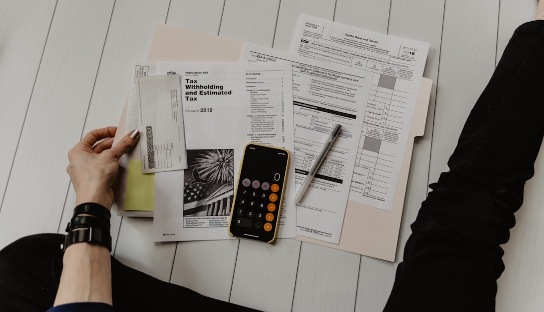 Person reviewing finances with paperwork and calculator while choosing a debt relief option