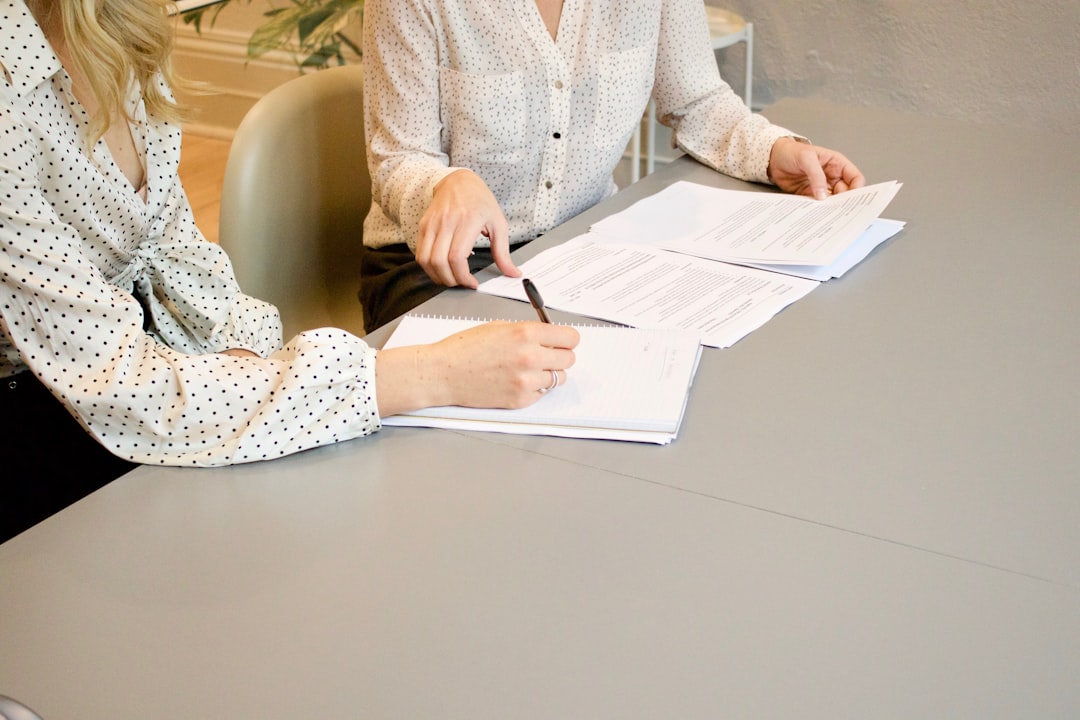 Borrower signing loan paperwork with a credit union loan officer after bankruptcy