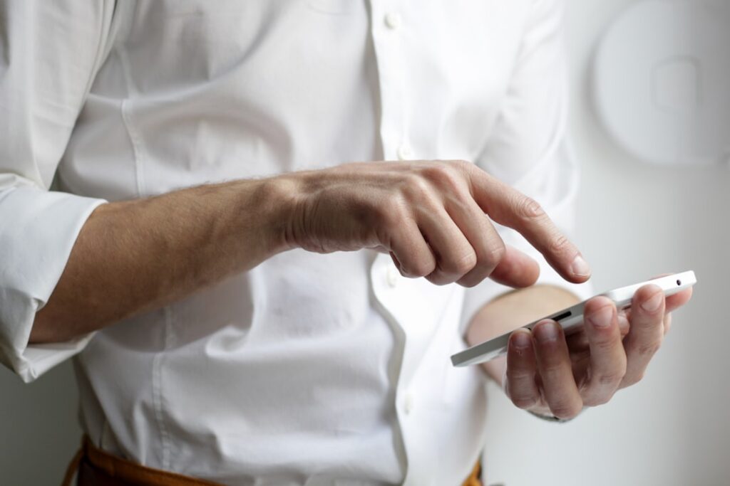 Consumer receiving debt collection text messages and emails on a smartphone in New York